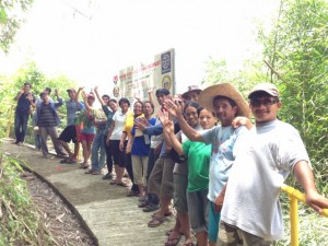 Community volunteers cheer with thanks, posing along their new and improved footpath funded by Kalahi-CIDSS.