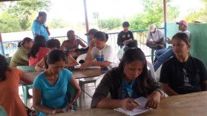 Ate Crestie (middle in front) carefully answers her workshop paper during the Community Volunteers’ Training.