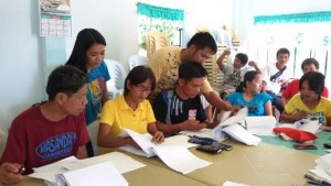 Manong Jun (in black) completes requirements for fund release for their subproject with the help of the Area Coordinating Team and community volunteers.